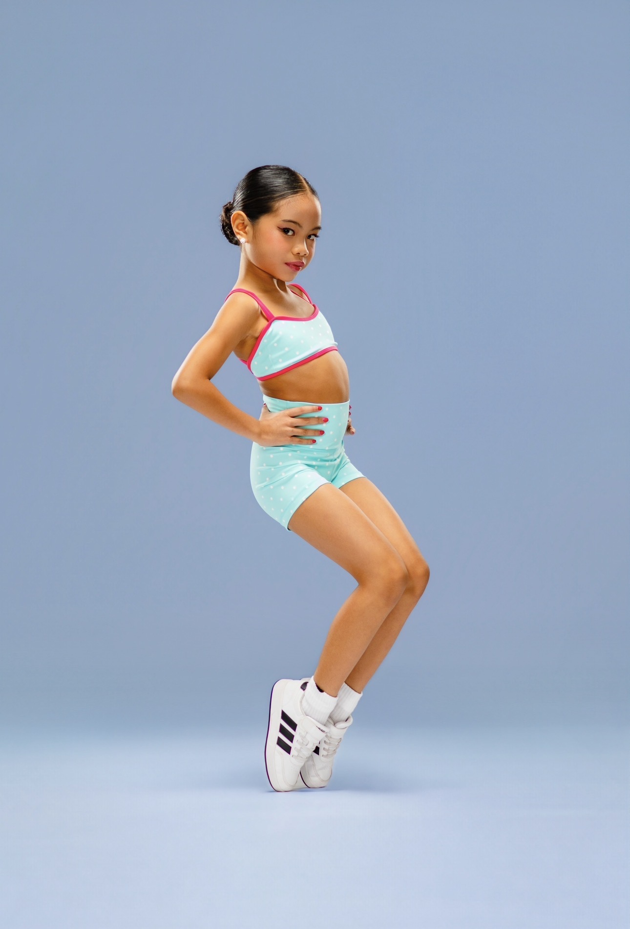 Pichara Luong posing in a mint and pink dance outfit with white sneakers